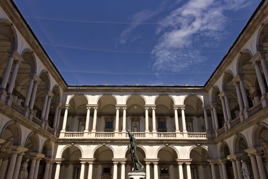 Milan, Lombardy, Italy, 04/27/2019. Brera Academy in Milan. Courtyard with arcade and columns. Around it is a portico with columns and in the center the statue of Napoleon.