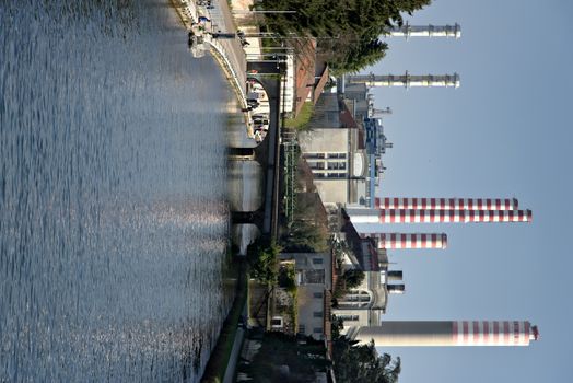 The industrial buildings and chimneys of the thermoelectric power station located near the Naviglio Grande canal 40 km from Milan.