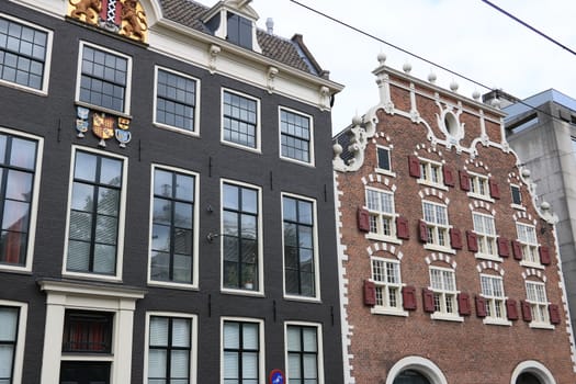 Amsterdam, Netherlands. About the July 2019. Typical red and gray brick houses with large white windows.