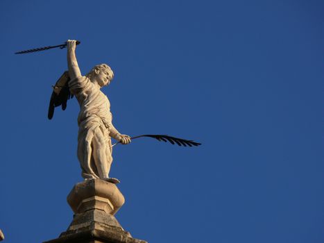  On top of a roof you can see this white marble sculpture with bronze pen and sword. Granada, Spain