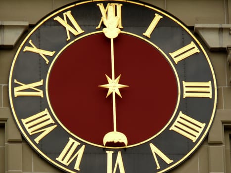 An original clock placed on the facade of a building and equipped with a single hand. 