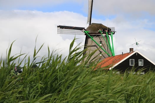 Amsterdam, Netherlands. About the July 2019.  Windmills of Zaanse Schans, near Amsterdam. The structures were used in the past to grind the cocoa beans used in nearby factories and to cut timber.