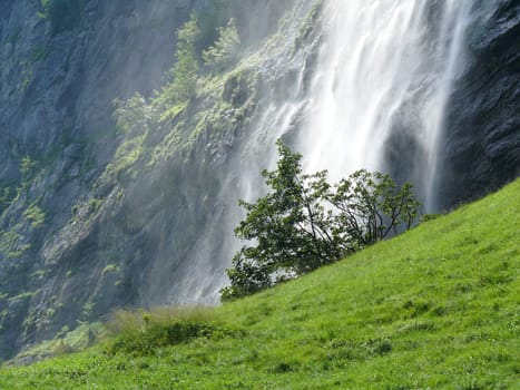 The water nebulizes in this waterfall in the alpine landscape.