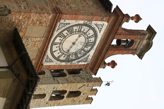 Towers with bell tower and large clock at the church of Impruneta, near Florence. Bell towers in terracotta and stone bricks.