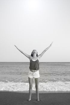 Mujer joven en la playa en actitud muy positiva y feliz. Precioso atardecer