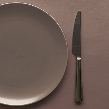 Empty plate and cutlery as mockup set on brown background, top tableware for chef table decor and menu branding design