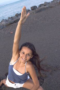 Young athlete woman practicing yoga on the beach. Beautiful sunset on the beach