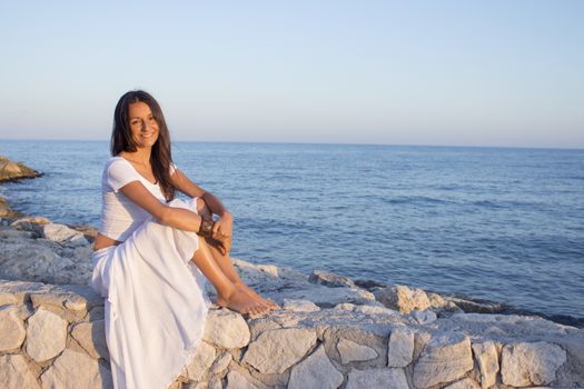 Woman in white dress on the beach with happy expression