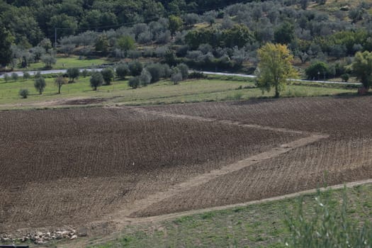 Road with cars on the Chianti hills. Cultivated fields and farmhouses in the Tuscan countryside near Florence. Greve in Chianti.