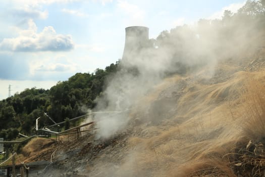 Monterotondo, Larderello, Tuscany, Italy. Geothermal field with fumaroles and steam pipes. Geothermal power station.Condensation towers in reinforced concrete.