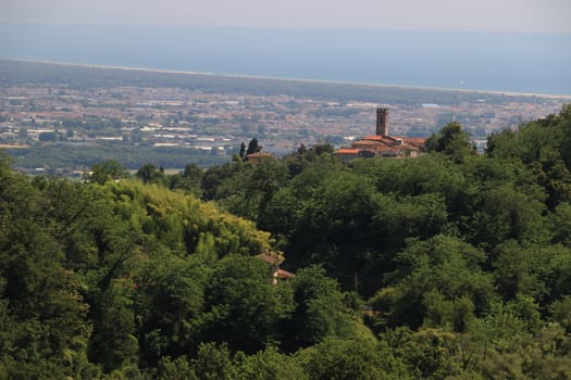 Ancient villages perched on the hills. In the background the sea and the Versilia coast.