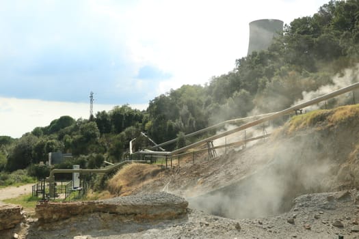 Monterotondo, Larderello, Tuscany, Italy.  Geothermal field with fumaroles and steam pipes. Geothermal power station.Condensation towers in reinforced concrete.