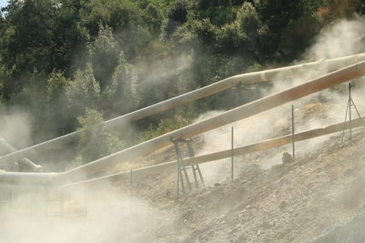 Monterotondo, Larderello, Tuscany, Italy. Geothermal field with fumaroles and steam pipes. Geothermal power station.Condensation towers in reinforced concrete.