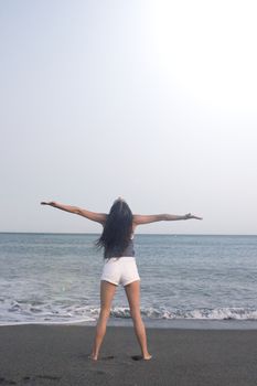 Mujer joven en la playa en actitud muy positiva y feliz. Precioso atardecer