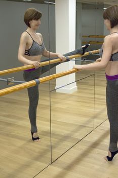 Female dancer doing leg stretches on the ballet barre
