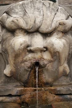 Carrara, Italy. About 9/2017. Fountain with carved Carrara marble mask.