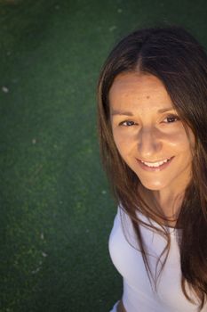 Portrait of young woman with happy expression. Green background