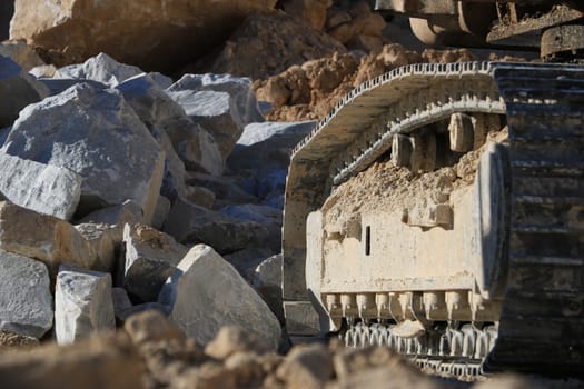 Excavator tracks in a marble quarry. Large excavators help men to extract white Carrara marble.