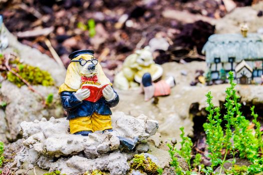 Three garden statue ornaments in a row sitting in a garden UK