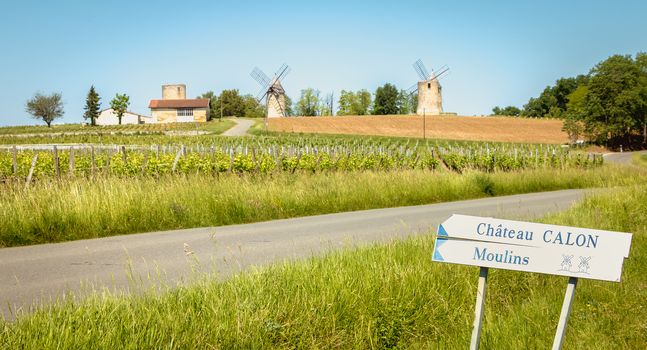 Calon near Bordeaux, France - May 26, 2017: Calon Castle Sign and Sign French Windmills Roadside on a Spring Day