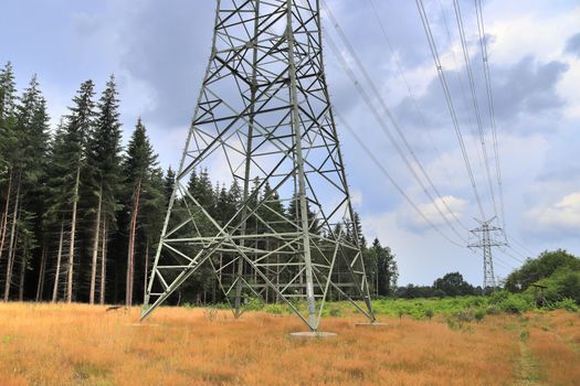 Close up view on a big power pylon transporting electricity in a countryside area in Europe