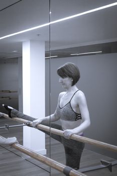 Female dancer doing leg stretches on the ballet barre