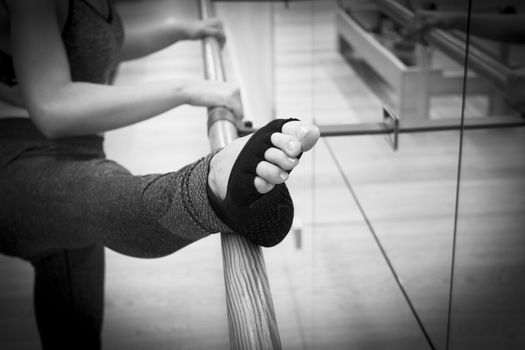 Female dancer doing leg stretches on the ballet barre
