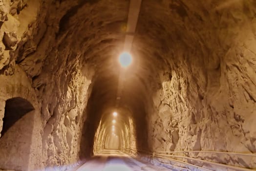 An ancient tunnel once used by trains and now driven by trucks transporting marble blocks from quarries to warehouses