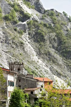 Colonnata, Carrara, Tuscany, Italy.  Bell tower of the church built with white marble pebbles. The ancient village, famous for its lard, is located in the heart of the Carrara marble quarries. 
  