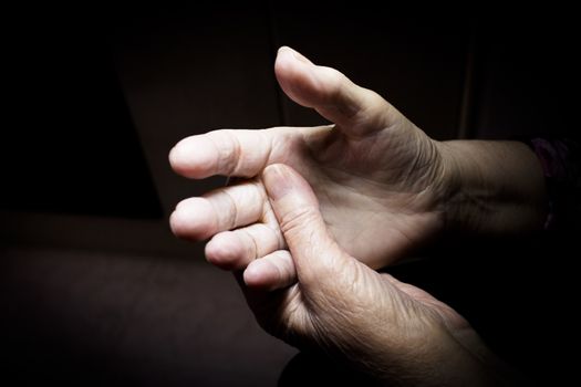 Hands of elderly woman doing a selfmassage. Manual physiotherapy 