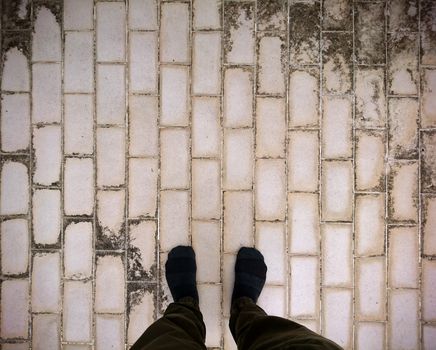 Foot wear sock standing on dirty ceramic tiles floor