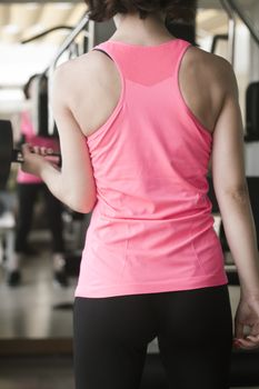 Girl doing exercise with 4 kg weights in the gym