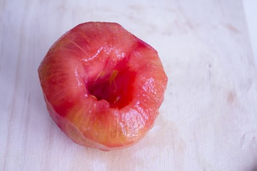 Peeled tomato on wooden cutting board. No people