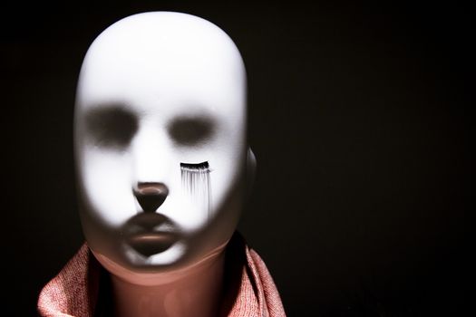 Female white mannequin head are eyelashes only in one eye. No people