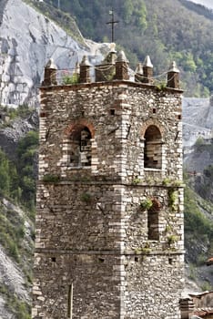Colonnata, Carrara, Tuscany, Italy. Bell tower of the church built with white marble pebbles. The ancient village, famous for its lard, is located in the heart of the Carrara marble quarries. 
  