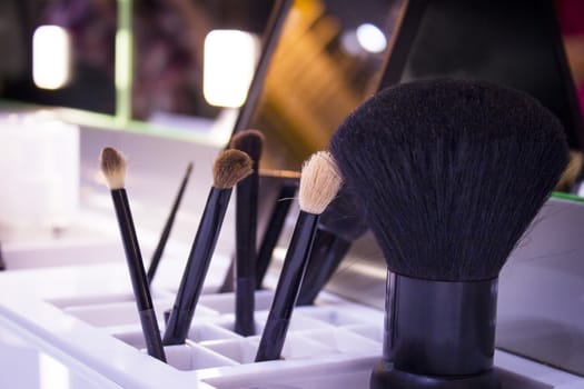 Plastic holder with various used makeup brushes. No people