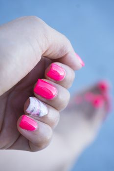 Womans hand showing her semipermanent manicure. Pink colour