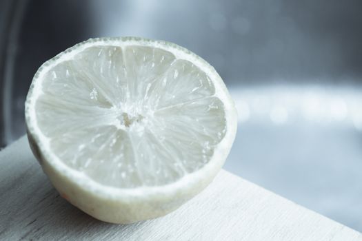 Half lemon cut on wooden cutting board. No people