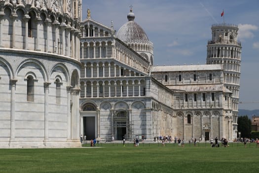 Pisa, Tuscany, Italy. 06/21/2019. Piazza dei miracoli of Pisa. Cathedral, leaning tower of the Tuscan city. Blue sky with clouds.