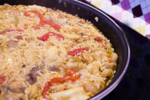 Rice paella cooked with chicken, seafood and vegetables. No people