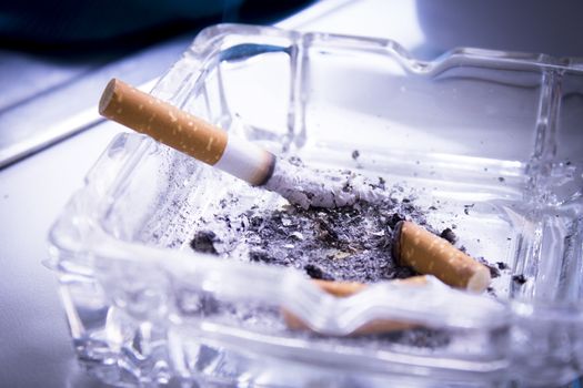 Ashtray with extinguished cigarettes full of ashes. No people