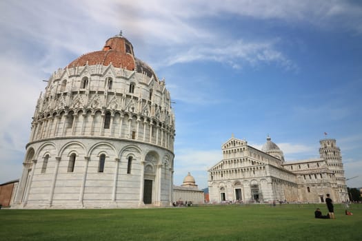 Pisa, Tuscany, Italy. 06/21/2019. Piazza dei miracoli of Pisa. Cathedral, tower and baptistery of the Tuscan city. Blue sky with clouds.