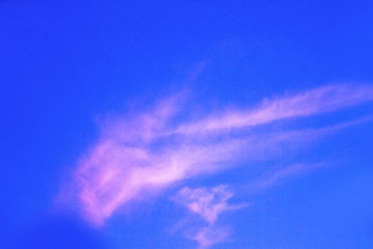 Reddish blue sky with small cloud. Copy space