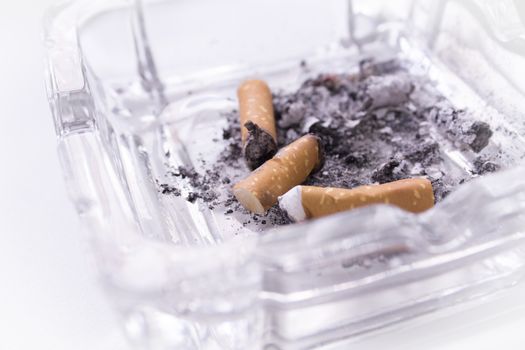 Ashtray with several cigarettes consumed and extinguished. Cigarette ash