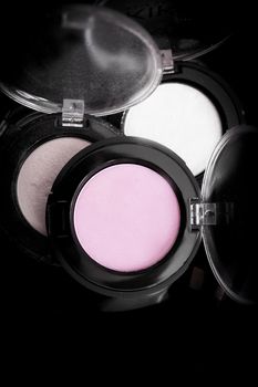 Various makeup shadows on dark background. No people