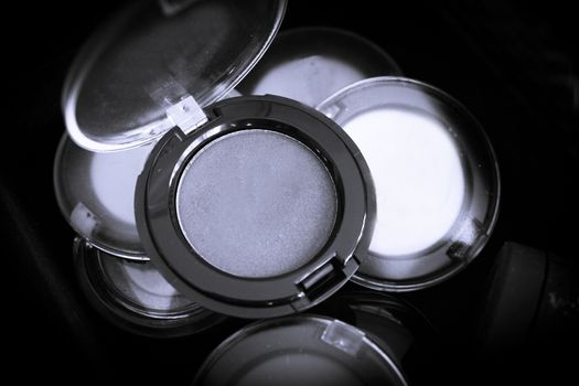 Various makeup shadows on dark background. No people