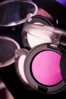 Various makeup shadows on dark background. No people