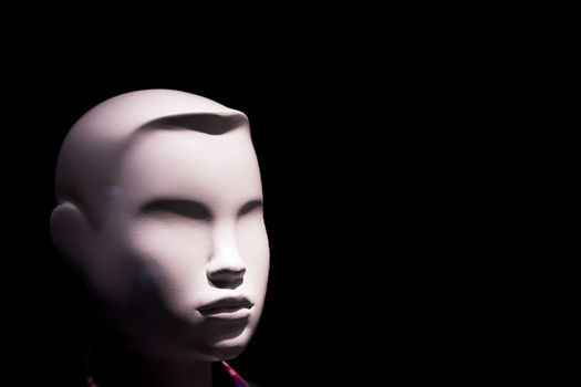 Child mannequin portrait on dark background without expression. No people