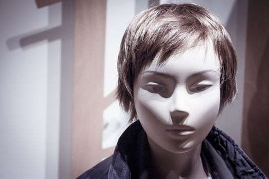 Young mannequin with short hair. Neutral expression. No people