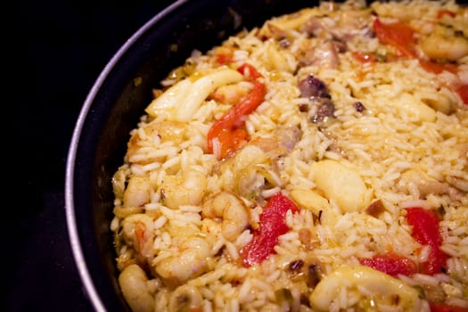 Rice paella cooked with chicken, seafood and vegetables. No people